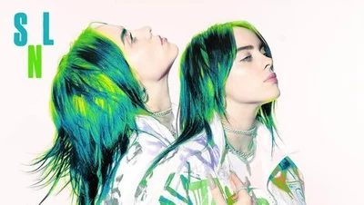 Portrait of singer Billie Eilish with black and neon green hair styling styled by Samantha Burkhart against a white backdrop.