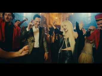 A man in a gold sequin blazer and a blonde woman dancing in a crowded ballroom styled by Simone Harouche