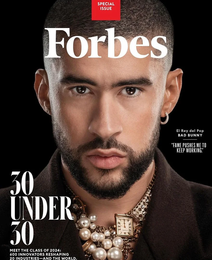 Forbes magazine cover features Bad Bunny in close-up wearing jewelry on a dark background. The '30 Under 30' special issue.