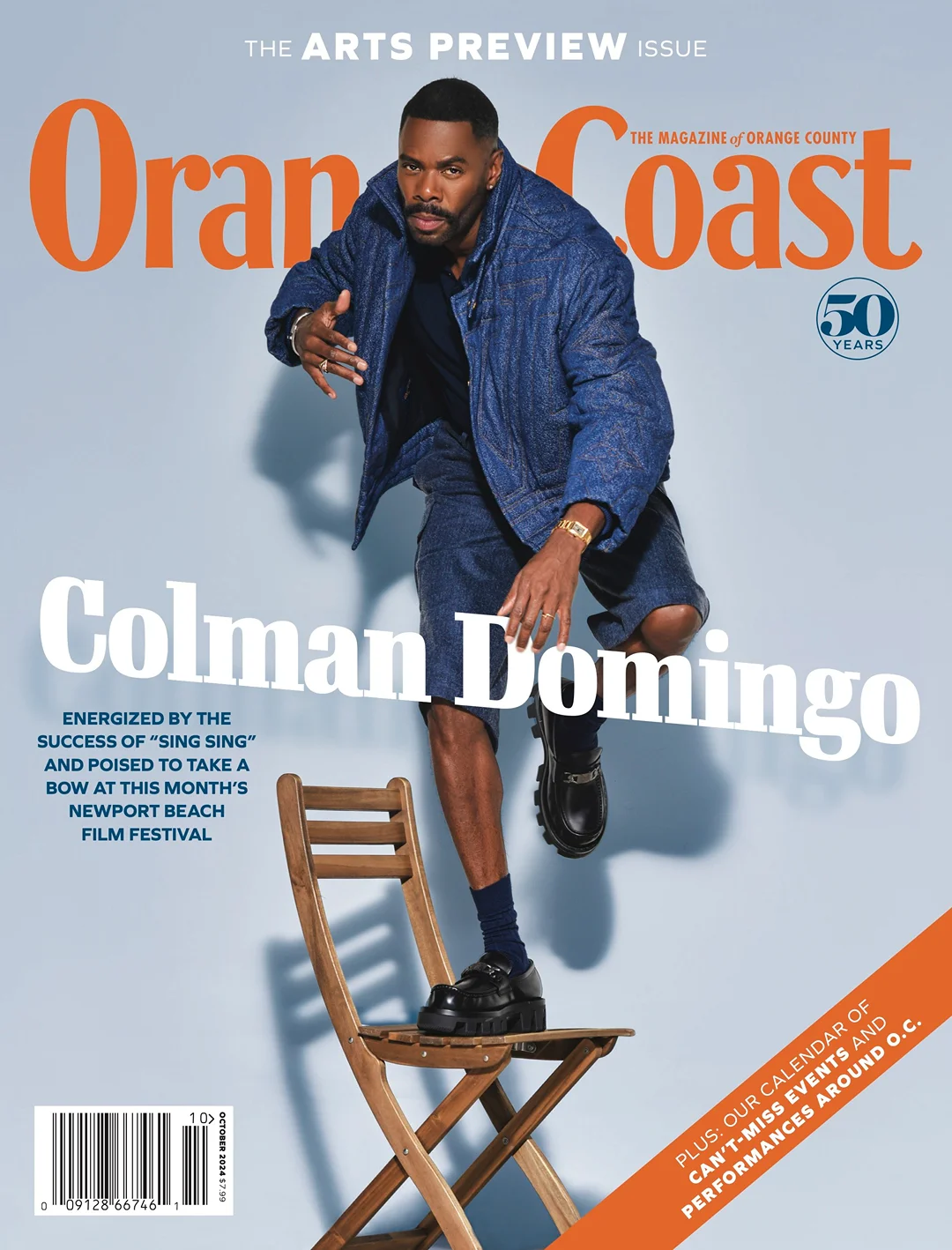 Magazine cover featuring Colman Domingo in a blue denim outfit balanced on a wooden chair against a light blue background.