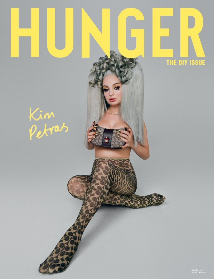 Kim Petras cover image for Hunger magazine; the singer wears patterned leggings and holds a patterned handbag while posing in a studio.