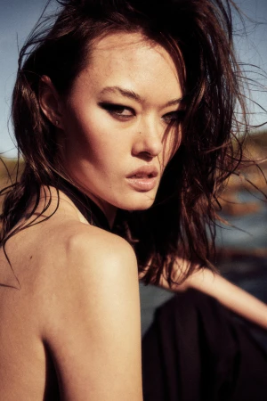 Close-up portrait of a woman with dark hair and striking eye makeup outdoors in Sydney by Jack Chesher
