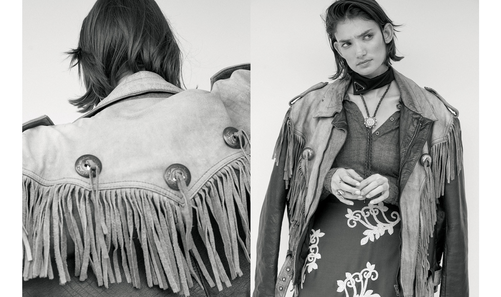Black and white fashion portrait of a female model wearing a fringed jacket, blouse, and skirt, posing in a neutral setting.