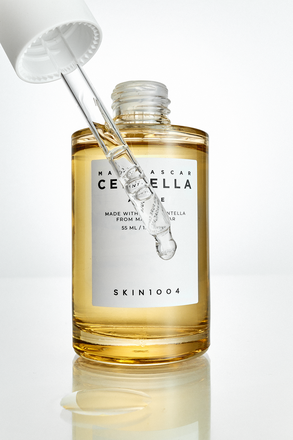 Cosmetic serum bottle with dropper. Skincare product shot in a studio setting with a focus on the clear liquid and minimalist packaging.