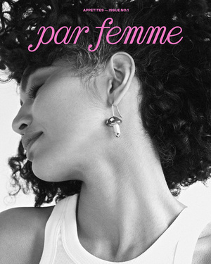 Black and white portrait of a woman wearing a mushroom earring and a white tank top by Sylve Colless
