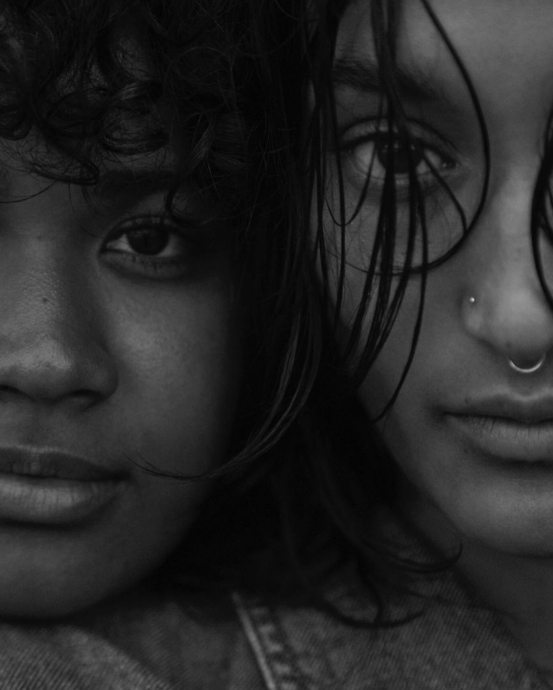 Close-up monochrome portrait of two people with wet hair and dark expressions captured by Sylve Colless.