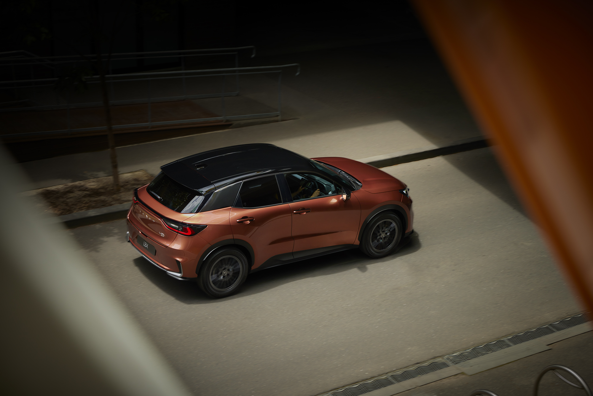 Copper-colored SUV with a black roof is parked outdoors on concrete. The vehicle is angled slightly to the left in low lighting.
