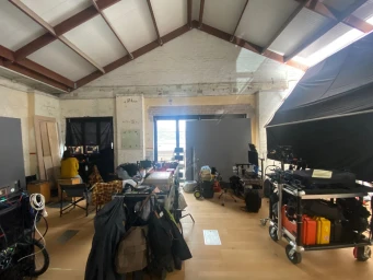 Behind-the-scenes view of a film production studio in Sydney with lighting equipment, monitors, and camera carts.