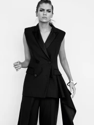 Model in black sleeveless blazer and trousers against seamless white background photographed by Regan Cameron.