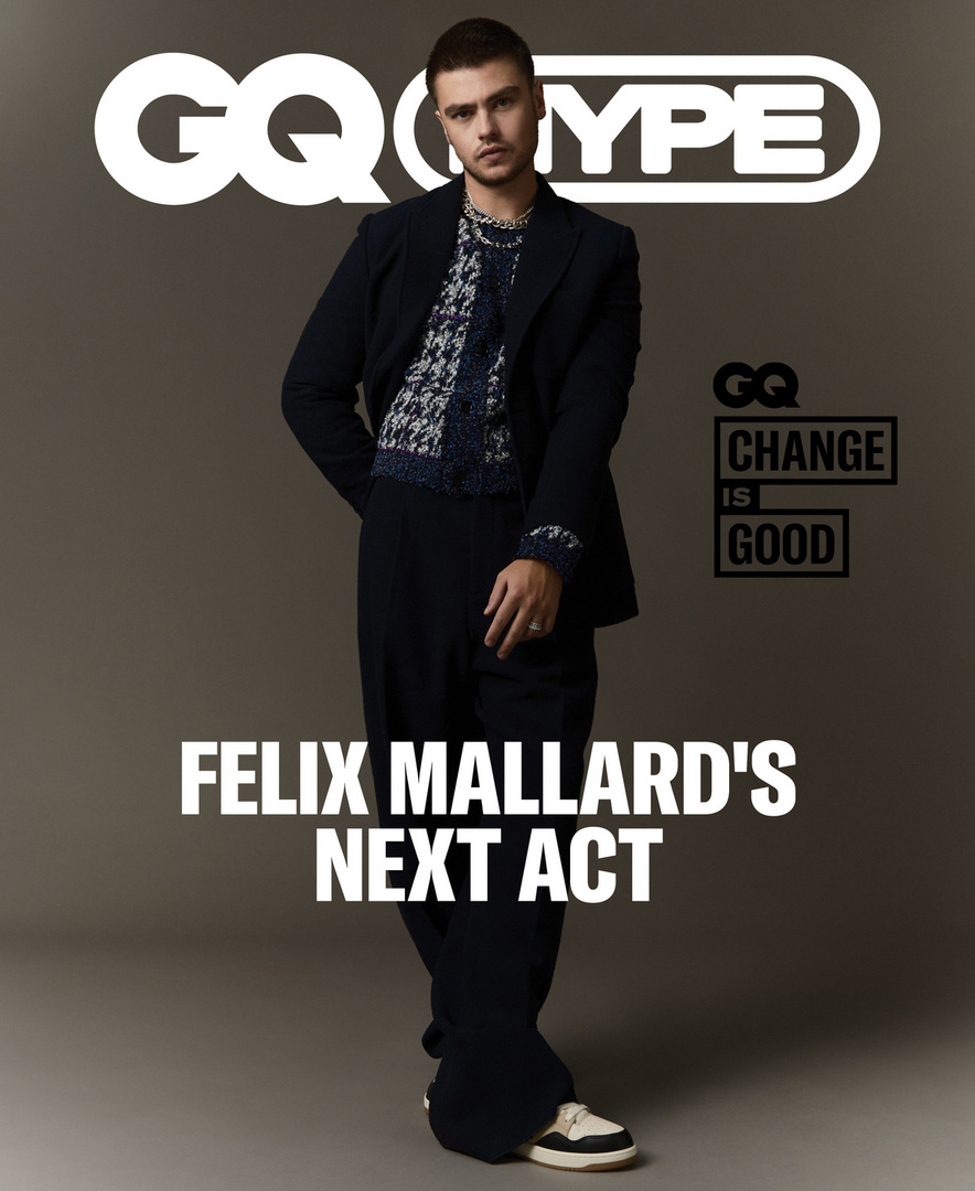 Felix Mallard poses in a navy suit and printed sweater for a GQ magazine cover, with the GQ logo and title text visible.