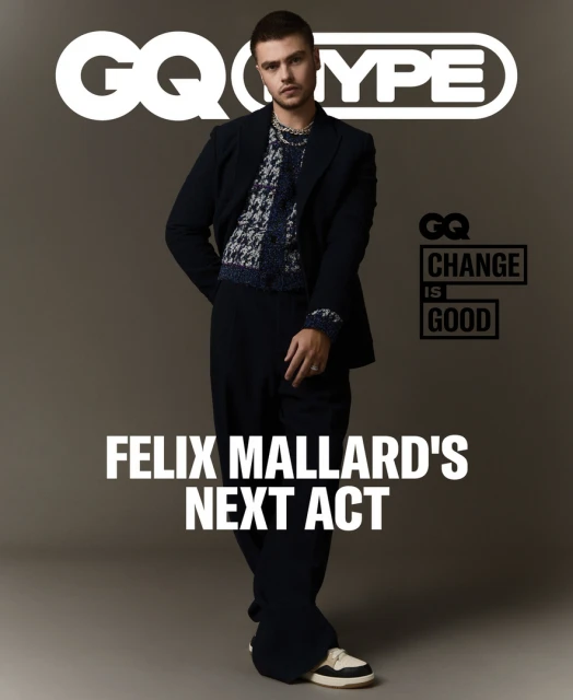 Felix Mallard poses in a navy suit and printed sweater for a GQ magazine cover, with the GQ logo and title text visible.