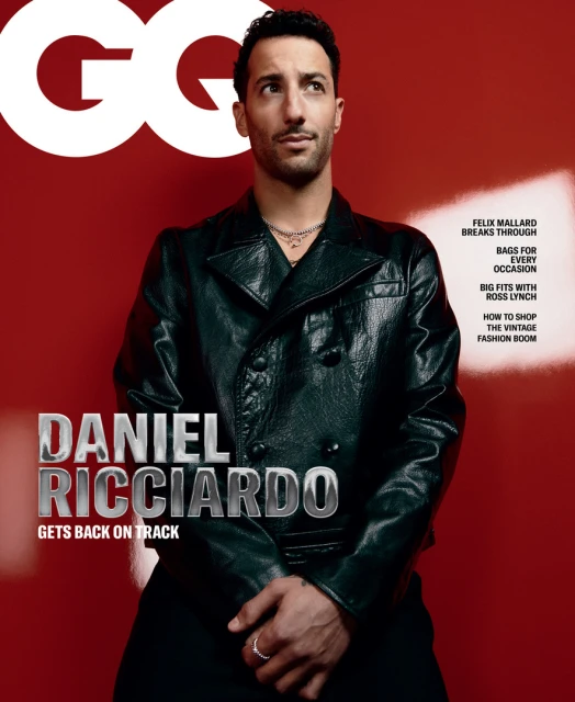 Daniel Ricciardo poses on the cover of GQ Magazine, wearing a black leather jacket against a red background with magazine text.