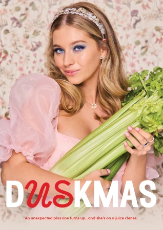 A young blonde woman holds a bunch of celery in front of a floral wallpaper, wearing a pink dress and jeweled headband. 