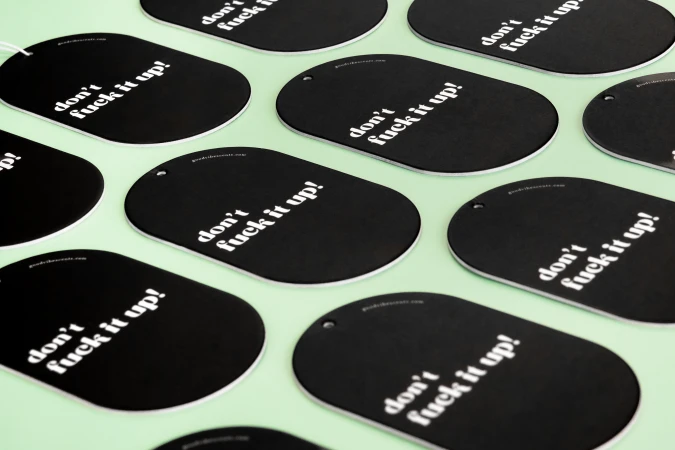 Several black oval tags with white text, arranged on a light green surface, creating a pattern with a consistent, graphic aesthetic.