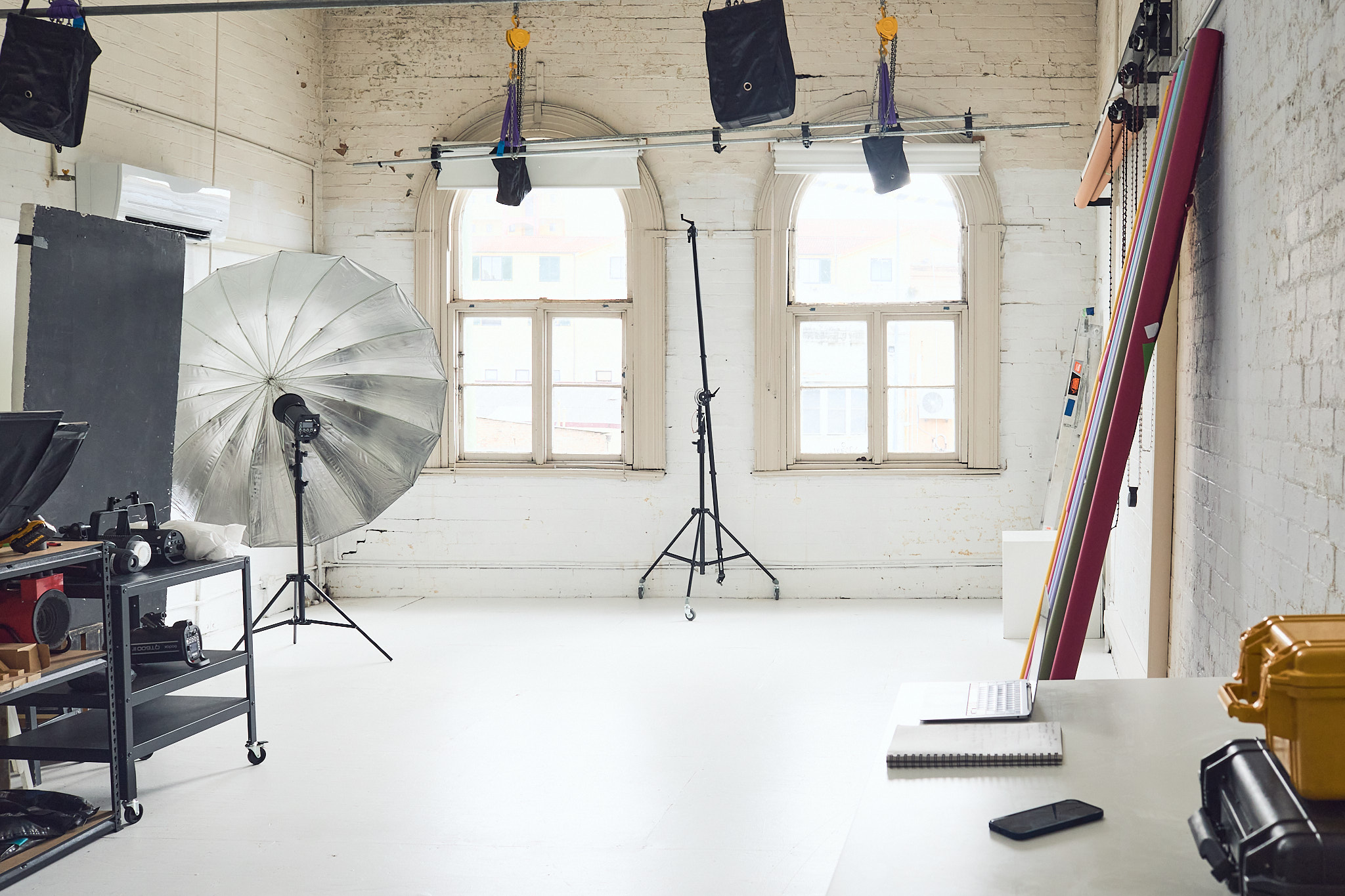 Photo studio setup with lighting equipment, props, and white brick walls creating a creative and professional interior space.