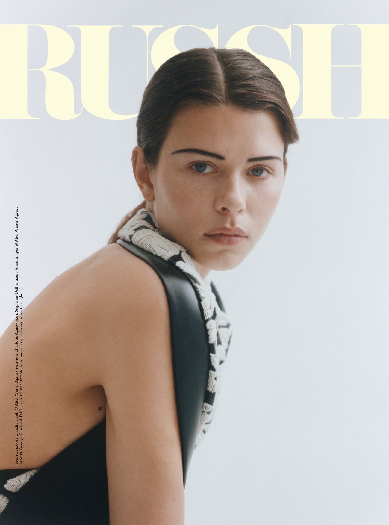 Magazine cover featuring a young woman with dark hair and light skin, wearing a black dress with intricate white floral embellishments.