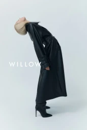 Blonde model arching backward wearing a black leather coat and heeled boots against a white background with text WILLOW.