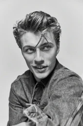 Portrait of a man wearing a denim shirt against a plain background