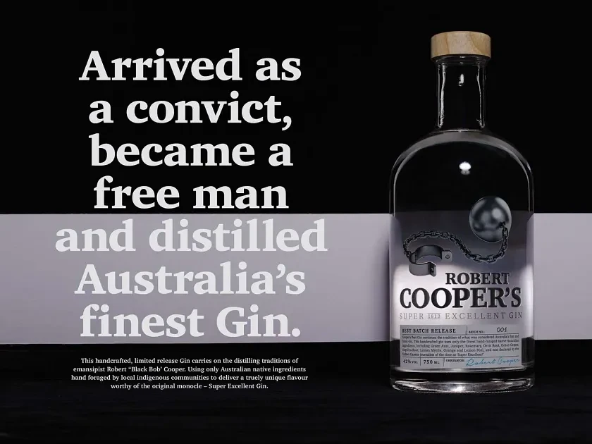 Robert Cooper's gin bottle with ball and chain detail against black and white backdrop with promotional text, studio shot.