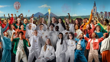 Large diverse group of smiling people in white tracksuits and colorful clothing celebrating together under a sunny sky