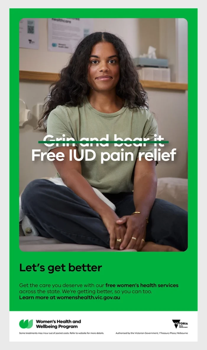 Woman seated wearing an olive green t-shirt and dark trousers in an interior healthcare setting with text overlay