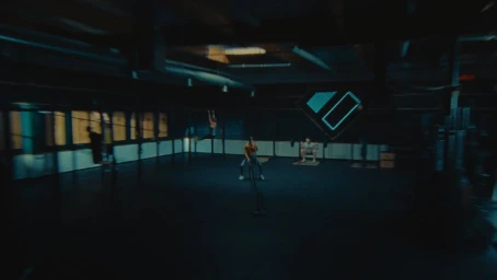 Wide shot of athletes working out inside a dimly lit industrial gym space directed by Christopher Gruse