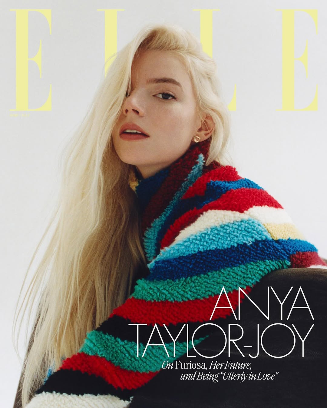 Anya Taylor-Joy cover for ELLE, portrait of an adult woman with long blonde hair, wearing colorful knit sweater, against white background.