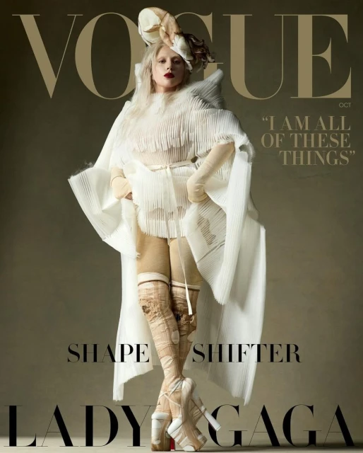 Vogue cover featuring Lady Gaga in a white avant-garde outfit and platform heels against a neutral background. Fashion editorial.