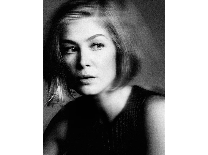 Black and white portrait of a woman with short hair wearing a dark ribbed top with subtle motion blur effect.