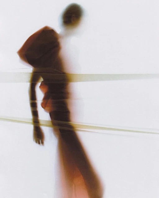 Blurred abstract portrait of person in red dress walking against white background with horizontal band for fashion or art projects.