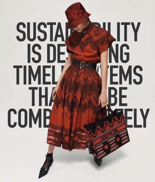 A woman in a red patterned dress and matching bucket hat, holding a branded tote, poses against a backdrop of bold white text.