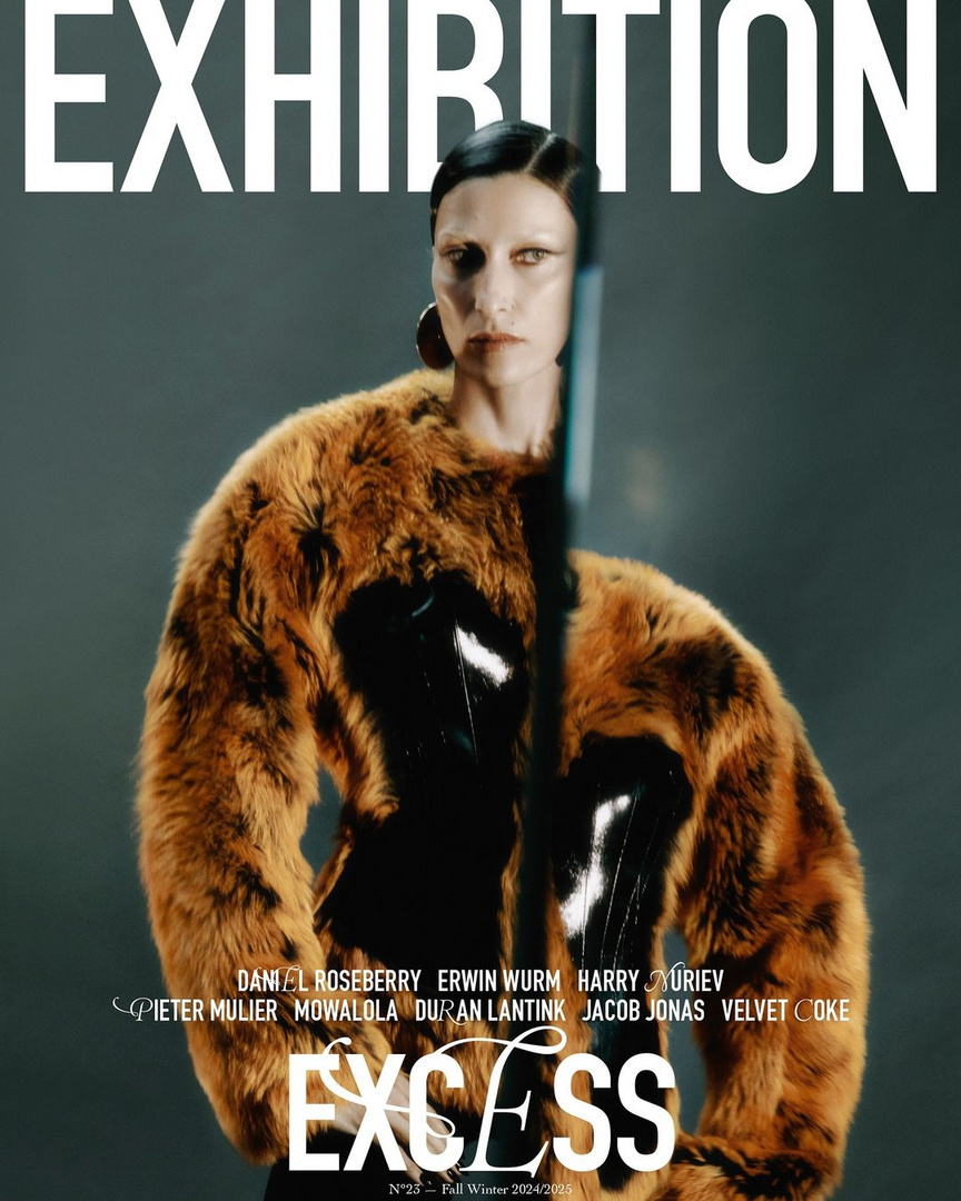 Magazine cover featuring a woman in a fur coat, geometric earrings, and slicked-back hair, set against a neutral gray background. Bold typography.