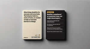 Two playing cards featuring typography, one cream and one black, displayed side by side on a neutral grey surface.