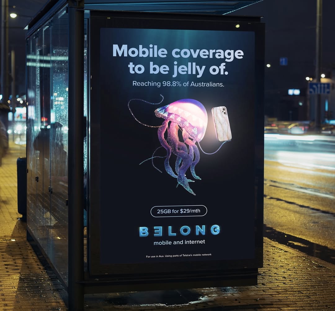 Mobile coverage ad with jellyfish and smartphone. Surreal advertisement on bus stop at night with text promoting internet services.
