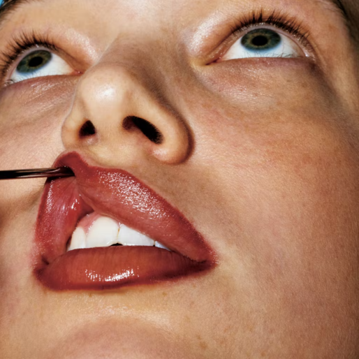 Close-up of a person with full red lips with a cosmetic needle inserting filler, emphasizing the beauty industry.