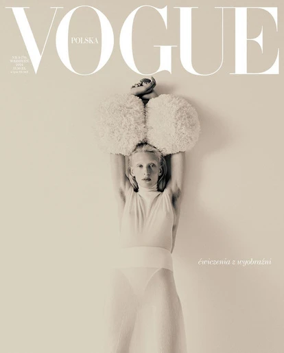Vogue Polska cover featuring a pale-skinned person in a white outfit with a large fluffy hat against a light beige background.