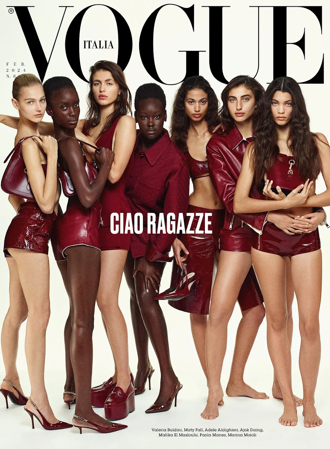 Vogue Italia cover featuring seven diverse adult female fashion models wearing matching red leather outfits and platform shoes against white.
