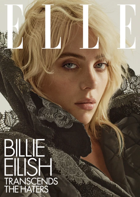 Close-up shot of Billie Eilish on the cover of Elle magazine, featuring a black lace-trimmed jacket and blonde wavy hair.