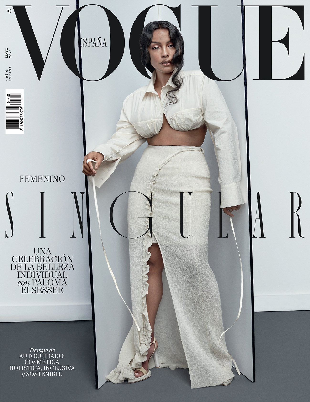 Vogue España cover featuring Paloma Elsesser in a white ensemble, posing against a grey backdrop, with the Vogue logo prominently displayed.