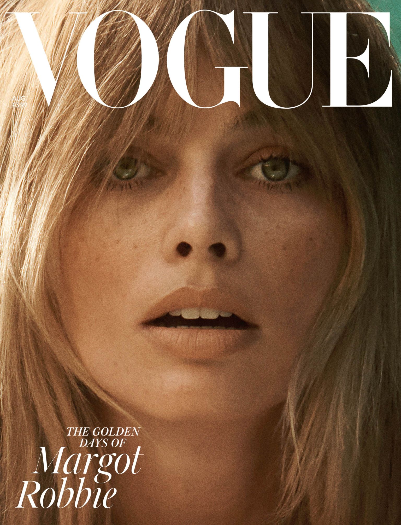Close-up of a woman with shoulder-length blonde hair, light skin, and freckles on the cover of Vogue magazine featuring the title 'Vogue'.