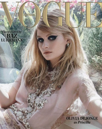 Close-up magazine cover portrait of Olivia DeJonge wearing a sheer embellished pink top with dramatic black eye makeup.