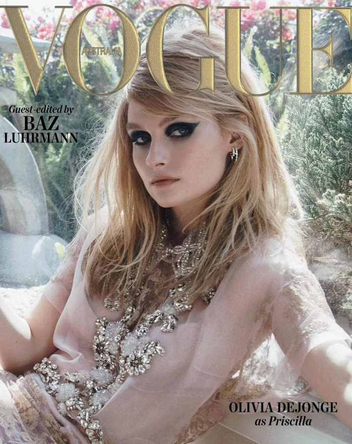 Close-up magazine cover portrait of Olivia DeJonge wearing a sheer embellished pink top with dramatic black eye makeup.