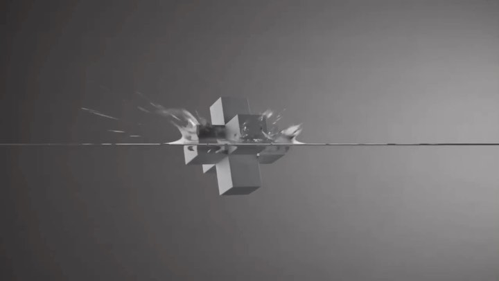 Abstract geometric cube shape partially submerged in water against a neutral grey backdrop, showcasing a visually striking scene.