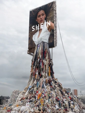 Fashion billboard with a woman wearing a garment made of discarded clothes on a landfill, promoting sustainability and ethical consumerism.