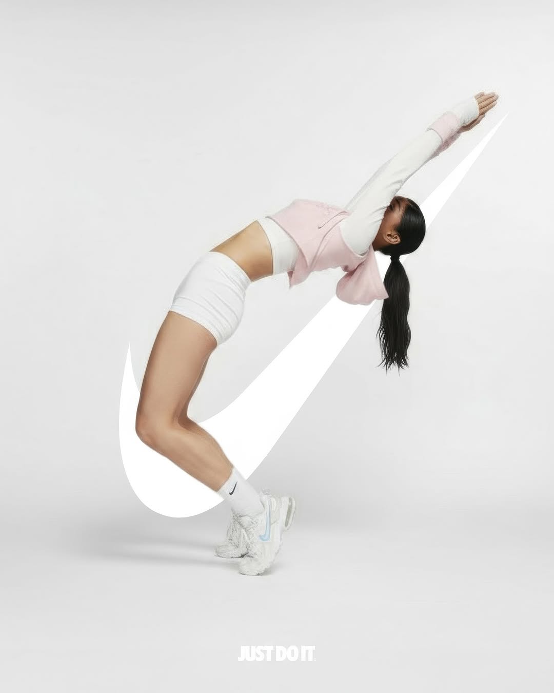 Athletic woman in activewear bends backward with outstretched arms next to the Nike swoosh logo against a white backdrop.