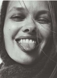 Close-up portrait of smiling woman with long blonde hair sticking out her tongue, shot by Aaron Feaver.