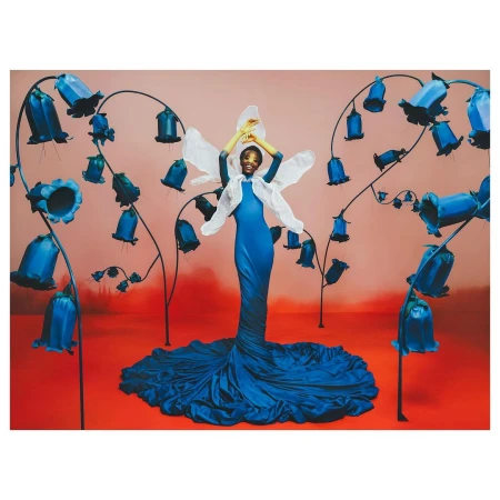 Elegant African-American woman posing in a blue dress with floral accents, set against a salmon and red backdrop, creating a dreamy fashion editorial.