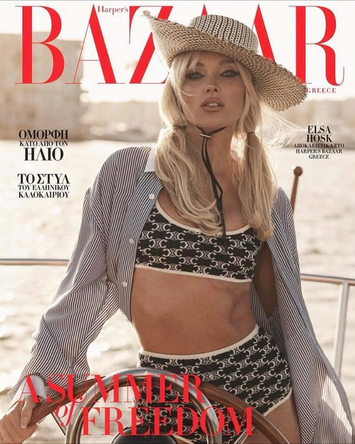Elsa Hosk wearing a patterned bikini and striped shirt for Harper's Bazaar Greece, posing on a boat in a wide shot.