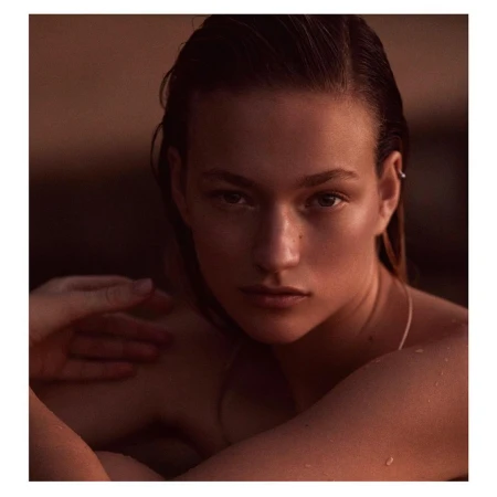 Close-up portrait of a woman with wet hair and shoulders, warm moody lighting, photographed by Adam Franzino.