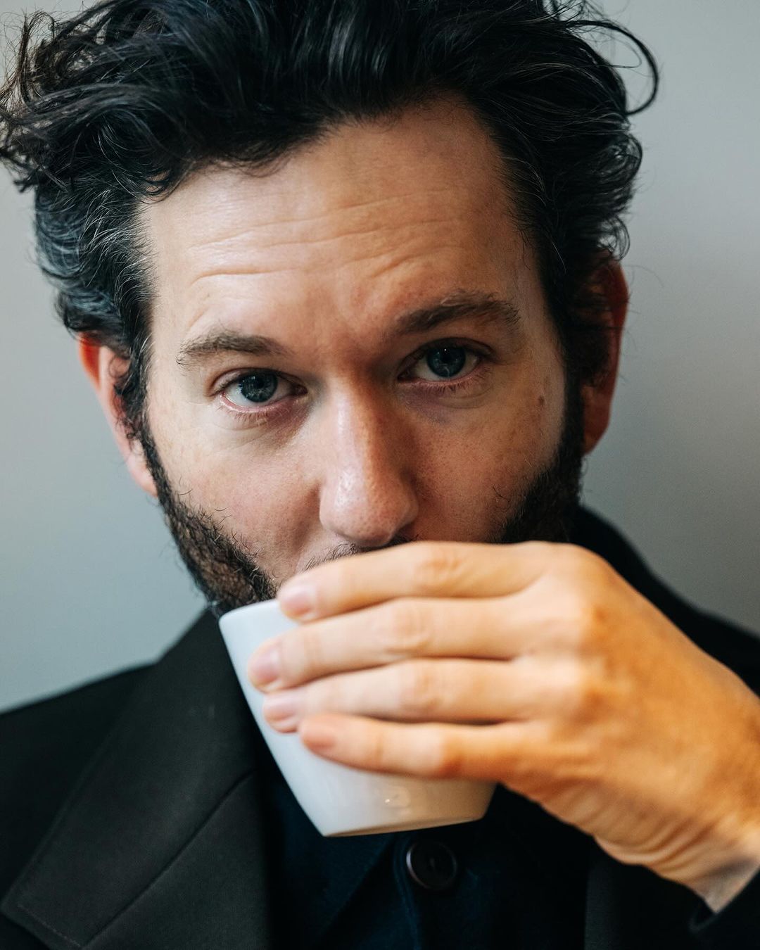 Close-up portrait of a man drinking from a white ceramic cup photographed by Adam Katz Sinding in New York